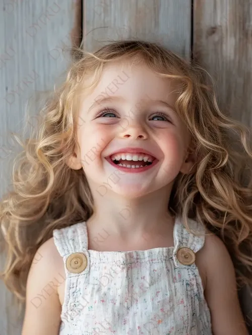 Bambina sorridente con capelli ricci e biondi su sfondo di legno