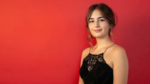 Giovane donna sorridente in abito elegante su sfondo rosso